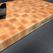 End Grain Maple Cutting Board with color filled personalized engraving on the side of the cutting board. Knife on top of cutting board for perspective.